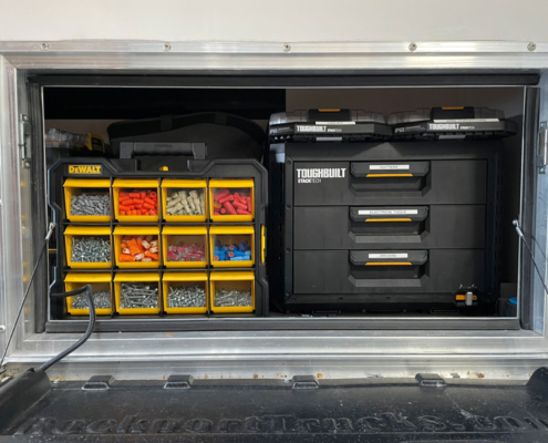 Sign installer accessing interior storage of Van Ladder Workport box during sign install