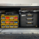 Sign installer accessing interior storage of Van Ladder Workport box during sign install